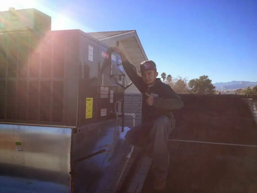 HVAC technician performing Heat Pump Repair on a rooftop unit in Raritan